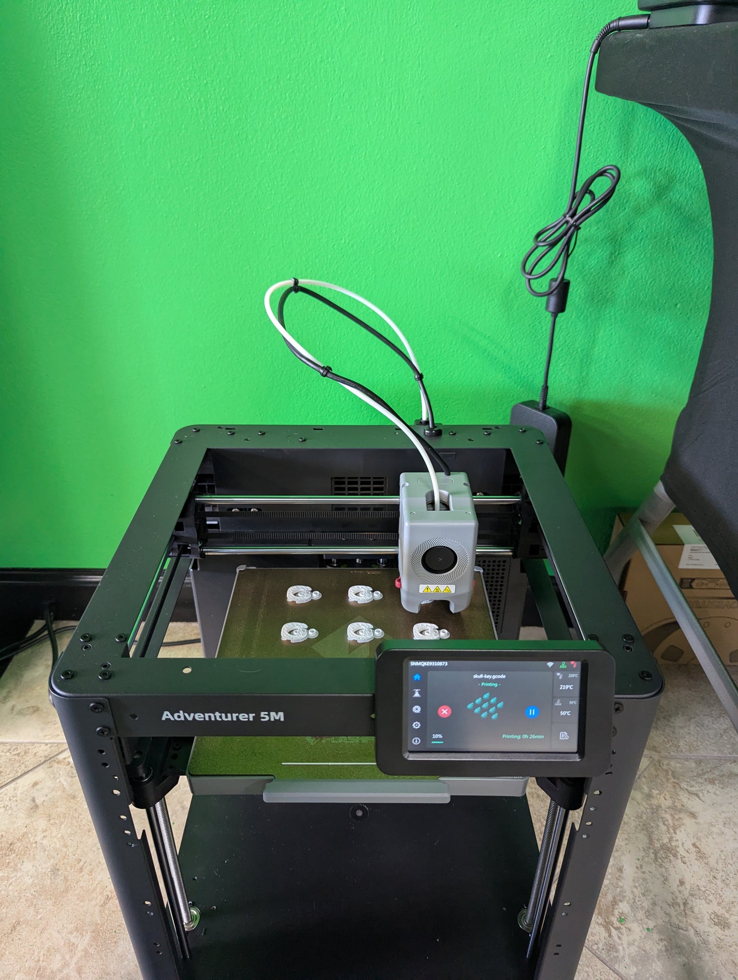 3D printer with 'Adventurer SM' branding on a green background