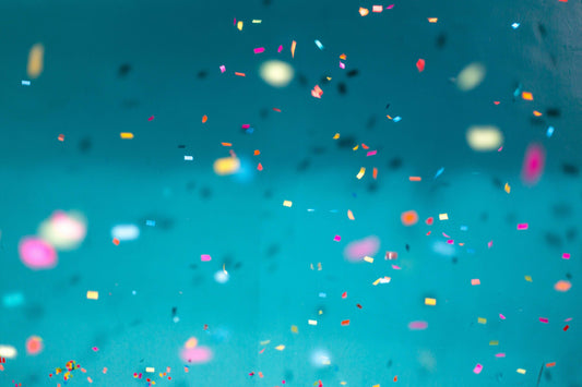 Blue background with colorful confetti, representing birthday celebration at Skull & Books VR